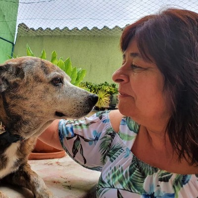 Foto de Solange Germano. Ela está olhando de frente para sua cachorra de estimação, com uma expressão de ternura